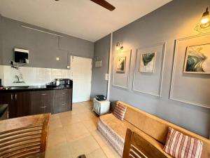 a living room with a couch and a kitchen at Subtlestays in Arpora