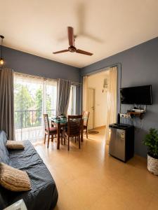 a living room with a table and a dining room at Subtlestays in Arpora