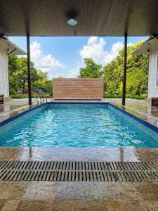 a swimming pool with blue water in a building at Angel Garden Farmhouse in Noida