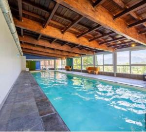 a large swimming pool with blue water at Duplex equipped for 6 people in Jausiers