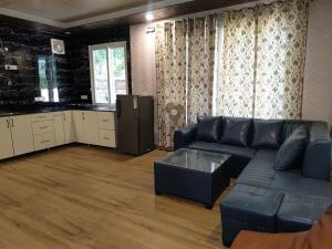 a living room with a couch and a kitchen at Angel Garden Farmhouse in Noida