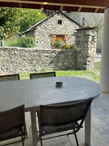 a table with two chairs and a stone building at Duplex equipped for 6 people in Jausiers