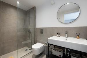 a bathroom with a sink and a toilet and a mirror at Lixouri Square Loft in Lixouri +33 photos