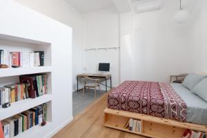 a bedroom with a bed and a desk and bookshelves at Lixouri Square Loft in Lixouri