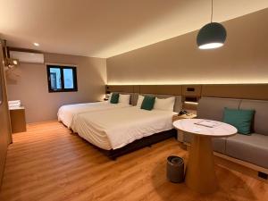 a bedroom with a bed and a table and a couch at 丰居中壢 Via Hotel Zhongli in Zhongli