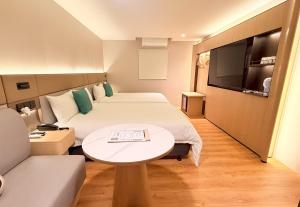 a hotel room with a bed and a table and a couch at 丰居中壢 Via Hotel Zhongli in Zhongli