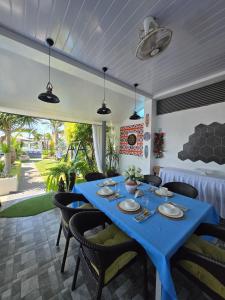 a dining room with a blue table and chairs at The beach house, Baroro Beachfront Villa in Bacnotan