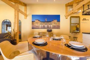 a dining room with a wooden table and chairs at L'échappée Ducale in Dijon