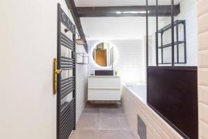 a bathroom with a black door and a sink at L'échappée Ducale in Dijon