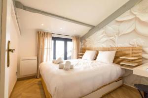 a bedroom with a large white bed and a window at L'échappée Ducale in Dijon