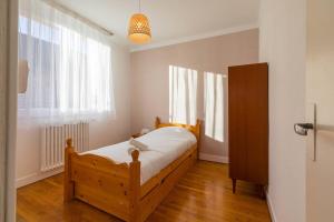 a bedroom with a wooden bed and a window at Sweet Villa Burgundy in Dijon