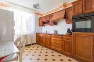 a kitchen with wooden cabinets and a black appliance at Sweet Villa Burgundy in Dijon