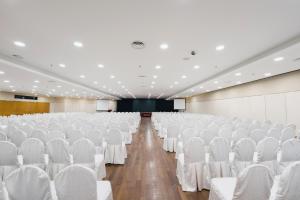 an empty hall with white chairs and a stage at 103 Hotel by manatidur in Kuala Lumpur