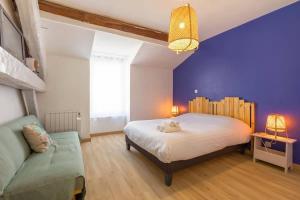 a bedroom with a large bed and a couch at La Cabotte d'Ahuy in Ahuy
