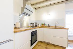 a kitchen with white cabinets and a sink at La Cabotte d'Ahuy in Ahuy