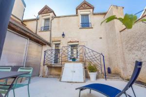 a building with a gate and chairs in front of it at La Cabotte d'Ahuy in Ahuy