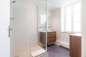 a bathroom with a glass shower and a sink at Le Duplex des Ducs in Dijon