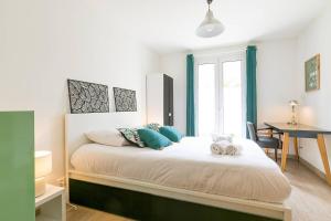 a bedroom with a large bed with blue pillows at La Chateaubriand in Dijon