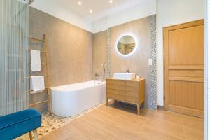 a bathroom with a tub and a sink and a mirror at La Chateaubriand in Dijon +13 photos