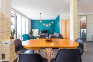 a living room with a wooden table and chairs at La Parenthèse in Dijon +7 photos