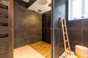 a walk in shower with a wooden ladder in a bathroom at L'essentiel in Le Creusot