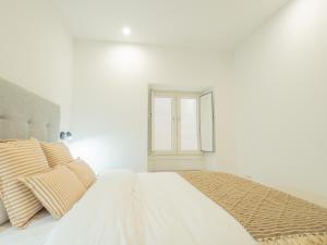 a white bedroom with a bed and a mirror at YBH Villa Lara in Villanueva de Arosa