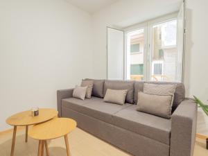 a living room with a gray couch and a table at YBH Villa Lara in Villanueva de Arosa