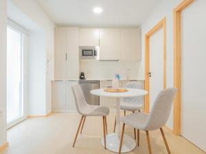 a white kitchen with a table and chairs at YBH Villa Lara in Villanueva de Arosa