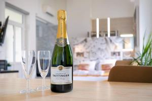 a bottle of champagne and two wine glasses on a table at Le Relax SPA in Dijon +9 photos
