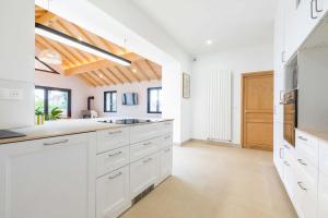 a kitchen with white cabinets and a wooden ceiling at La Balzac in Dijon