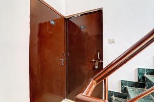 a wooden door in a room with stairs at Hotel O Raama in Lucknow
