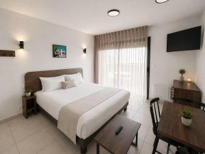 a bedroom with a bed and a table and a desk at Nemea Appart Hotel Les Hauts de Milady Biarritz in Biarritz +57 photos