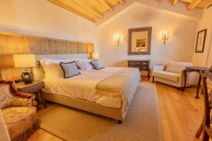 sypialnia z dużym łóżkiem i krzesłem w obiekcie Marvão Hotel Museu w mieście Marvão