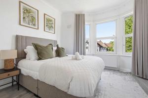 a white bedroom with a large bed and a window at The Forest- Silverwood in Cambridge