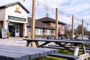 a wooden picnic table in front of a restaurant at Kingstown Hotel by Greene King Inns in Hull