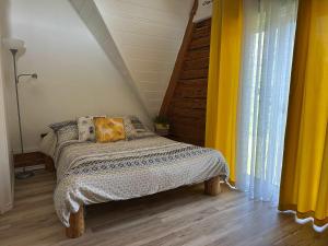 a bedroom with a bed and a yellow curtain at Spa Swimming Pool & Nature - Chalet rang 3 in Roberval +8 photos