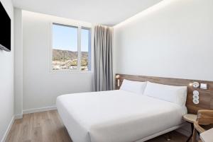 a white bedroom with a large bed and a window at B&B HOTEL Cieza in Cieza +36 photos