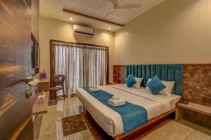 ein Schlafzimmer mit einem Bett mit blauen Kissen in der Unterkunft Holiday Plus in Panchgani