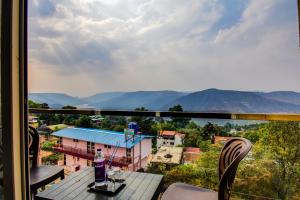 Blick von einem Balkon mit Tisch und Stühlen in der Unterkunft Holiday Plus in Panchgani