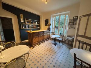 a room with a bar with tables and chairs at Bon Chez Nous in Saint-Amand-Jartoudeix