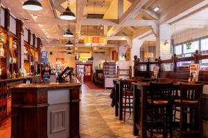 a bar with wooden stools and tables in a restaurant at Kingstown Hotel by Greene King Inns in Hull