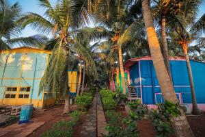 a row of palm trees in front of a building at La PAVI RESORT in Auroville