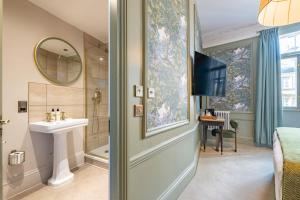 a bathroom with a sink and a shower and a mirror at Crescent Inn by Maison Pierre in Ilkley
