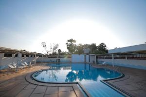 a large swimming pool with blue water at La PAVI RESORT in Auroville