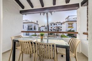 a dining room with a table and chairs on a balcony at Urbanización El Oasis, 20 Villas en 1ª Línea Playa in Denia