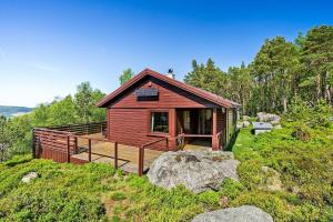 a small red cabin with a deck on a hill at Panoramic View - near Pulpit Rock in Strand +23 photos