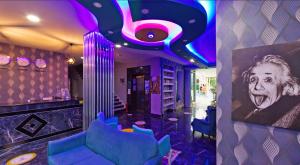 a room with a bar with blue chairs and a painting at Yade Luxe Hotel in Marmaris