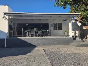 a building with a porch with a gate and stairs at Charla on the Beach in Gordonʼs Bay +32 photos