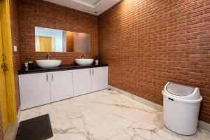 a bathroom with two sinks and a brick wall at Hotel Classic Crown - #Scenic mountain view #open terrace #guest preferred #best selling hotel in Mussoorie in Mussoorie +55 photos