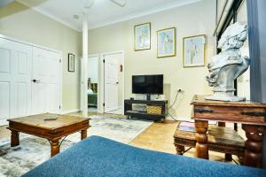 a living room with a statue on a table and a television at Lismore Hillside Home on Ballina Road in Lismore